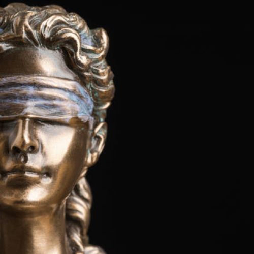 Portrait of the blindfolded goddess of justice Themis isolated on black background with copy space, as a legal concept